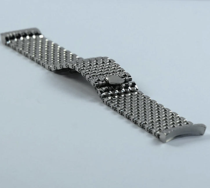 Metallic watch strap on a light blue background